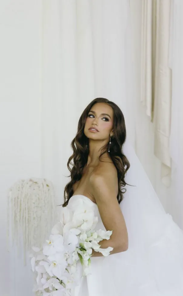 Real Glowtoure bride with a luminous, natural bridal glow holding a white orchid bouquet