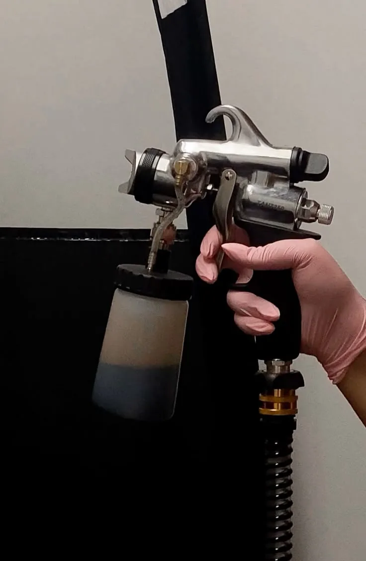 A Glowtoure custom spray tan being applied with a professional airbrush