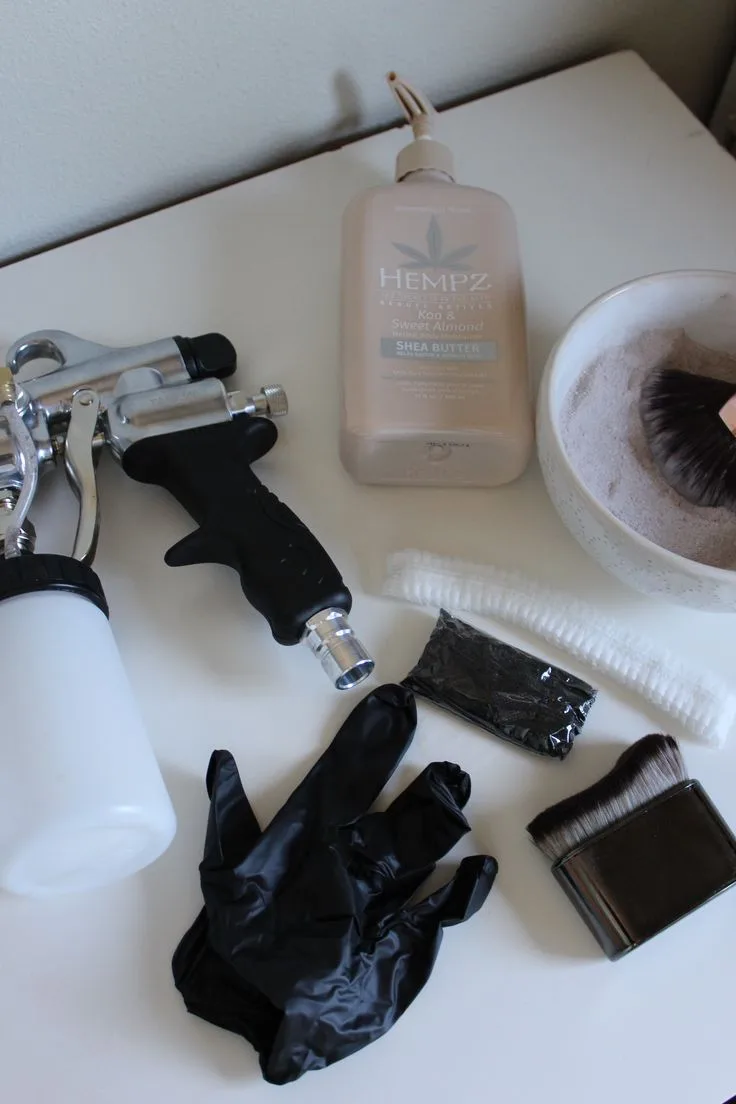 Glowtoure spray tan tools, barrier cream, and finishing powder laid out before a session