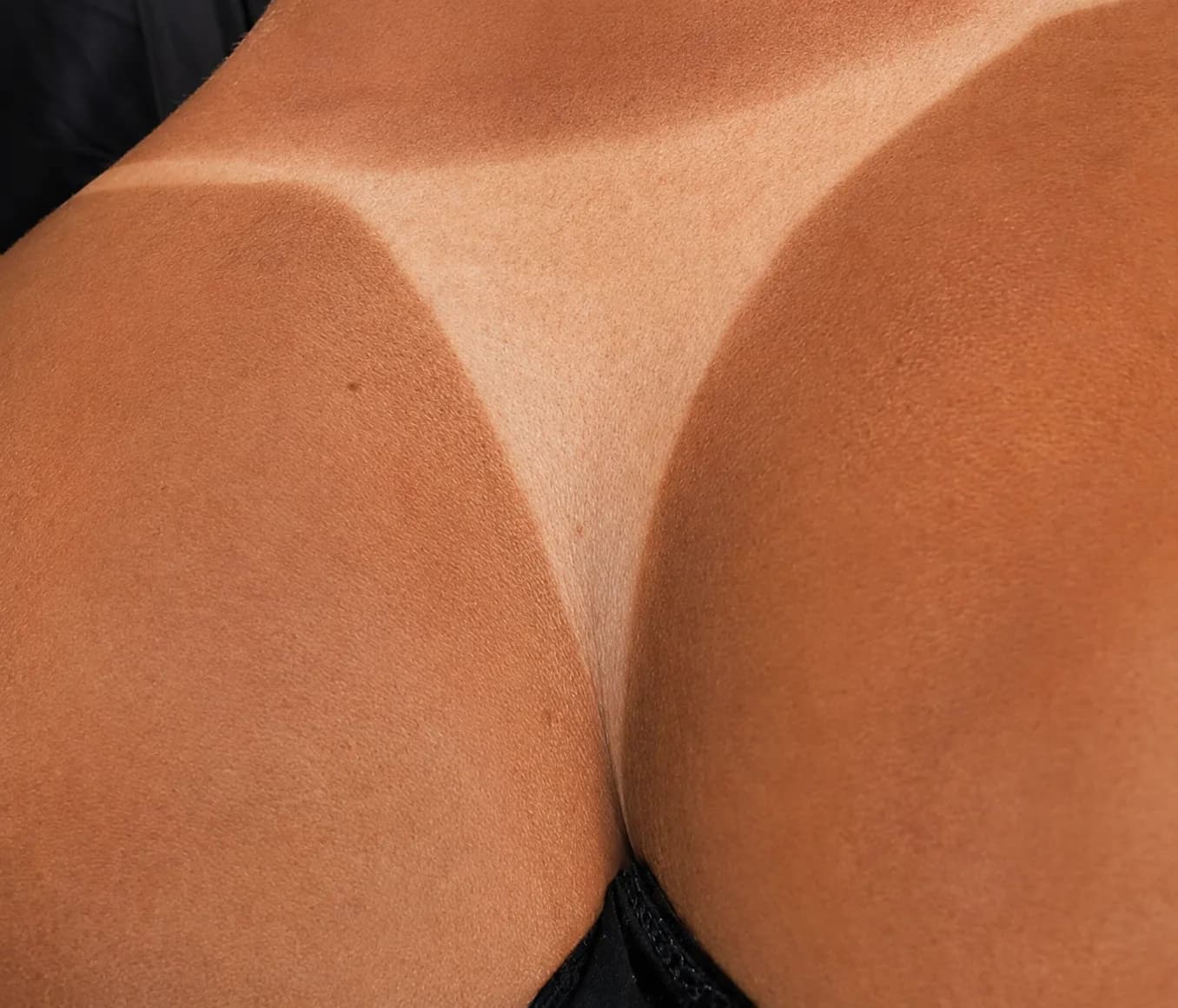 Real Glowtoure client result — a deep, even spray tan with a clean, crisp tan line across the lower back